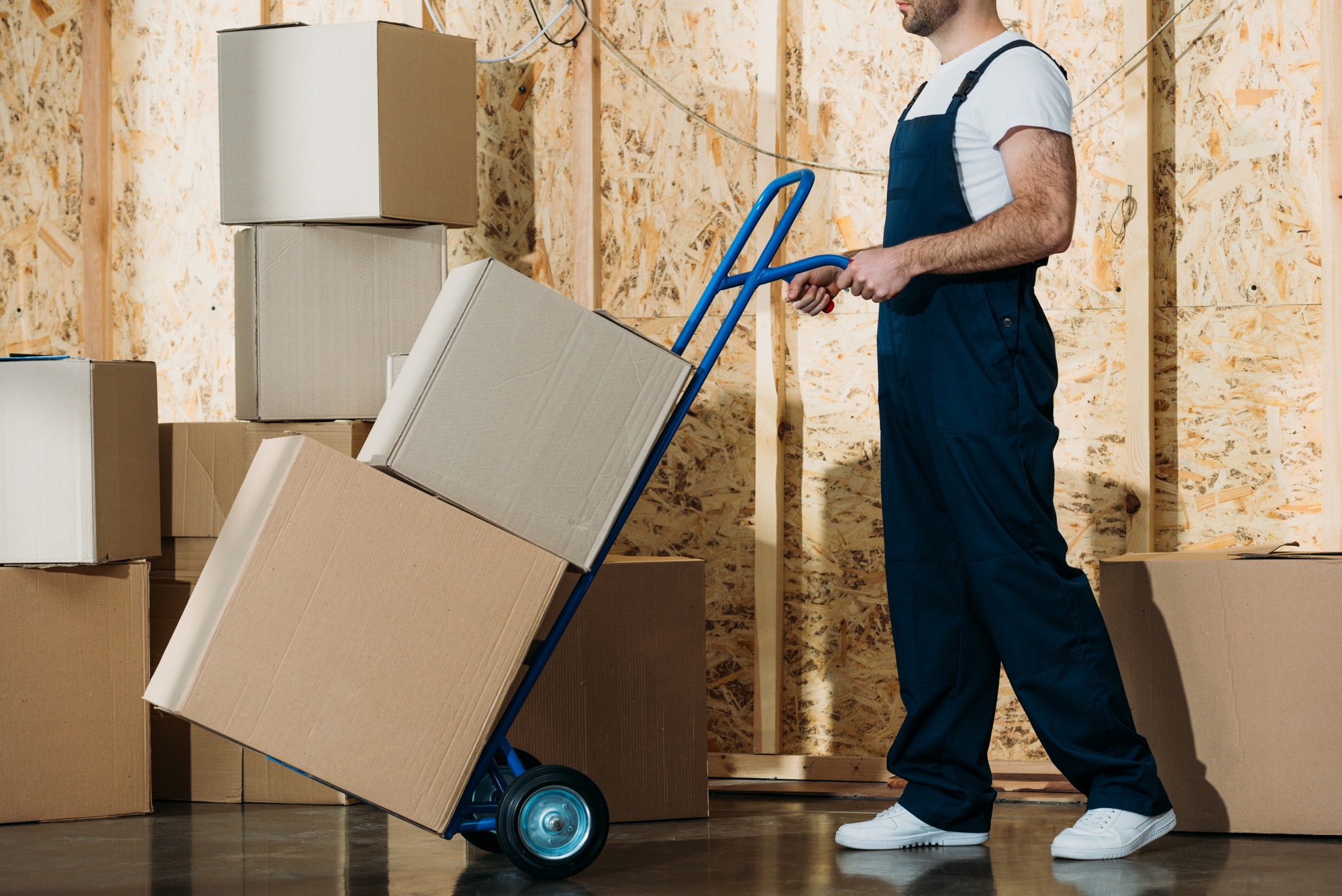 delivery-man-carrying-boxes-on-hand-truck.jpg